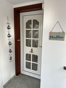 a white door with a window in a room at Sielhuus in Neuharlingersiel +1 photo