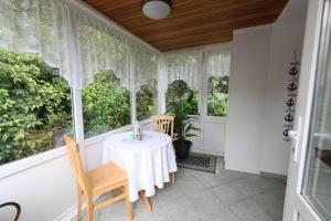 a porch with a table and chairs and windows at Sielhuus in Neuharlingersiel