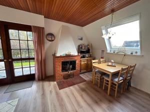 a dining room with a table and a fireplace at Sielhuus in Neuharlingersiel