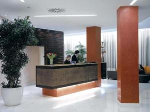 a lobby with two people sitting at a counter at Hotel Habitat in Giussano