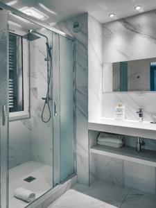 a bathroom with a glass shower and a sink at Grand H&ocirc;tel Dauphin&eacute;, Boutique H&ocirc;tel & Suites in Toulon