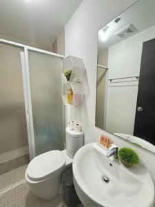 a bathroom with a sink and a toilet and a mirror at Condotel Abreeza Ayala Mall in Davao City