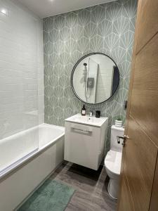 a bathroom with a white toilet and a mirror at New, Luxury Apartment in Town Centre in Cheltenham +12 photos