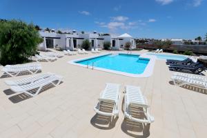 grupa leżaków i basen w obiekcie Salmarina Bungalows w Puerto del Carmen