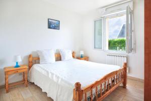a bedroom with a large bed and a window at Les Tamaris du Nord - Maison à 300m de la plage in Portbail