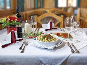 a table with a bowl of food on a white table cloth at Gasthof Hirschen in Sibratsgfäll