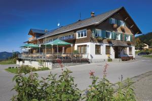 a large building with a porch and a balcony at Gasthof Hirschen in Sibratsgfäll