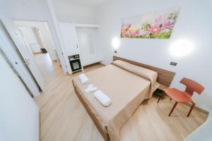 a small bedroom with a bed and a red chair at Guest Room 144 in San Giovanni in Fiore