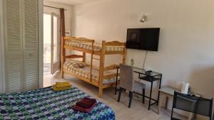 a bedroom with a bunk bed and a television at LE TRANSAT 40m de la plage in Palavas-les-Flots +118 photos