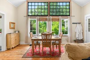 a dining room with a table and chairs and a window at Artist Lane Cottage in Nashville +26 photos