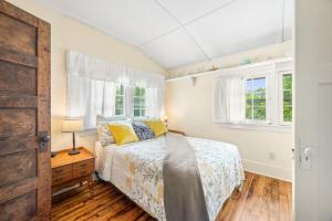 a bedroom with a bed and two windows at Artist Lane Cottage in Nashville