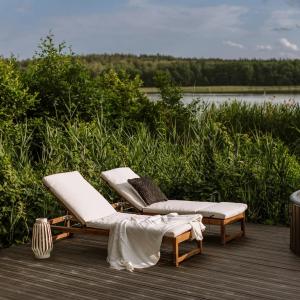 two lounge chairs on a deck near a body of water at BonnieClyde in Beattock