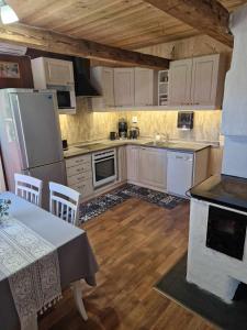a kitchen with white appliances and a table with chairs at Kalda Puhkemaja in Helmküla