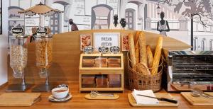 a table with bread and baskets of food on it at CITY PARC HOTEL - Proche Paris Nord & CDG Aéroport - Parc des Expositions in Aulnay-sous-Bois +23 photos