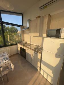 a kitchen with a white refrigerator and a sink at BeSanVito - Sea Apartments in Taranto