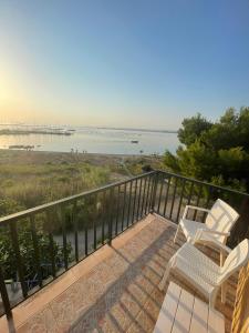 a balcony with two chairs and a view of the beach at BeSanVito - Sea Apartments in Taranto