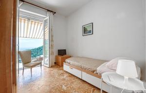 a bedroom with a bed and a chair and a window at Cozy Home In Sori With House Sea View in Sori