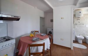 a kitchen with a table with a red table cloth on it at 1 Bedroom Cozy Apartment In Longobardi in Longobardi +4 photos