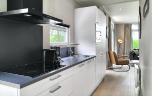 a kitchen with white cabinets and a black counter top at 2 Bedroom Nice Home In Hellendoorn in Hellendoorn