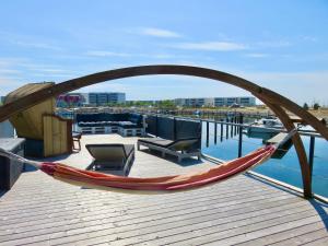 a hammock on a deck next to the water at Hausboot Fehmarn in Fehmarn
