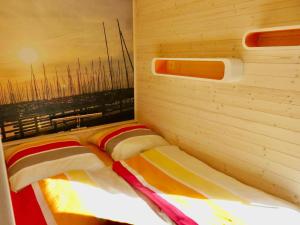 a bedroom with two beds in a wooden wall at Hausboot Fehmarn in Fehmarn