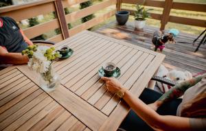 two people sitting at a table on a deck with a dog at Holiday Home Ostróda Rus Mala Ii in Ostróda