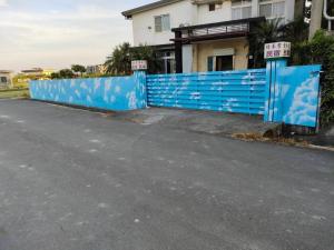 a blue fence in front of a house at Lu He Feng Homestay in Luodong
