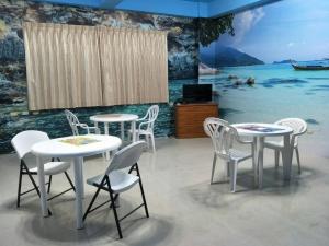 a group of tables and chairs in a room with a mural at Lu He Feng Homestay in Luodong