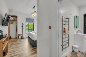 a bedroom with a bed and a bathroom with a sink at Pass the Keys Larkey View a Tranquil Space for Two in Chartham +6 photos