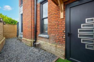 a black door on the side of a brick building at Pass the Keys Larkey View a Tranquil Space for Two in Chartham
