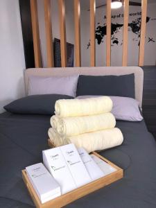 a bed with white towels and books on it at Luxurious Deluxe Apartment - EhubStay Mactan Cebu - Saekyung Condo Looc in Lo-oc