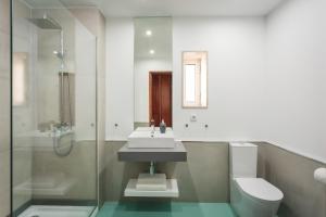 a bathroom with a sink and a toilet and a shower at BeSmart Residence by Home Sweet Home Aveiro in Aveiro +29 photos