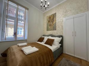 une chambre avec un grand lit avec des serviettes dessus dans l'établissement Apartament Barska Park, à Przemyśl