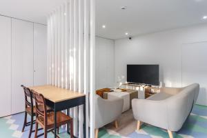 a living room with a table and chairs and a television at BeSmart Residence by Home Sweet Home Aveiro in Aveiro