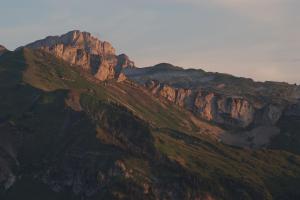 a view of a mountain with the sun shining on it at Gasthof Hirschen in Sibratsgfäll