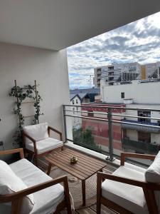 a balcony with chairs and a view of a building at Appartement au centre de Villeurbanne in Villeurbanne