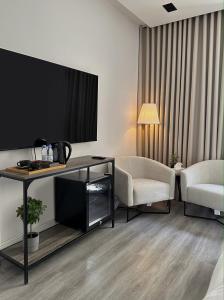 ein Hotelzimmer mit einem TV, einem Tisch und Stühlen in der Unterkunft استديو شمال الرياض in Riad