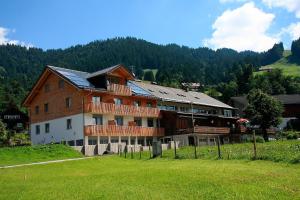 a large building on a hill in a field at Gasthof Hirschen in Sibratsgfäll