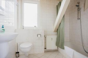 a white bathroom with a toilet and a sink at Ferienwohnung Emma in Güntersberge +27 photos