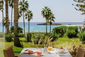 a table with food and a view of the ocean at Nissi Beach Resort in Ayia Napa