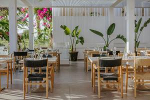 a restaurant with tables and chairs and plants at Nissi Beach Resort in Ayia Napa