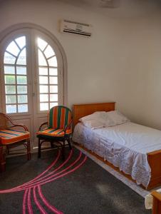 Un dormitorio con una cama y dos sillas y una ventana. en North Coast Marwa Resort Villa, en Dawwār ‘Abd Allāh 28 fotos más