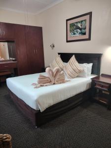 a hotel room with a bed with two towels on it at Gooderson Leisure Natal Spa Self Catering and Timeshare Resort in Paulpietersburg +112 photos