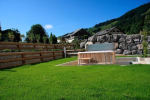 a wooden bench in a yard with a fence at Gasthof Hirschen in Sibratsgfäll