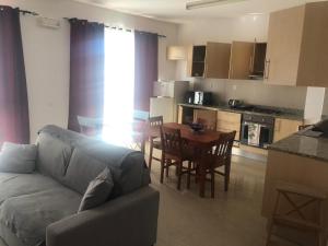a living room with a couch and a table and a kitchen at Apartamento Oiá Mindelo in Mindelo +3 photos