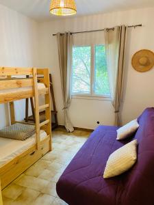 ein Schlafzimmer mit Etagenbett und Fenster in der Unterkunft Magnifique Villa typique du Sud avec Piscine privée et jardin méditerranéen in Saint-Vincent-de-Barbeyrargues