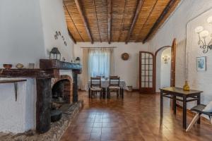 a living room with a fireplace and a dining room at Villa Laura by Wonderful Italy in Alghero