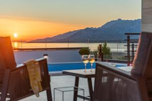 a balcony with a table and two glasses of wine at Villa Malusy ZadarVillas in Rovanjska