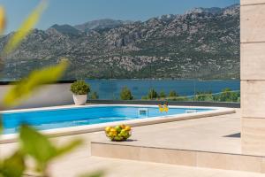 a swimming pool with a view of a mountain at Villa Malusy ZadarVillas in Rovanjska