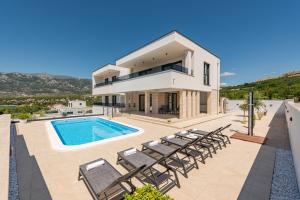 Villa con piscina y sillas en Villa Malusy ZadarVillas, en Rovanjska